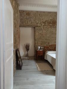 1 dormitorio con 1 cama en una pared de piedra en Piazza San Giorgio, en Dolianova