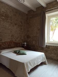 1 dormitorio con cama y ventana en Piazza San Giorgio, en Dolianova