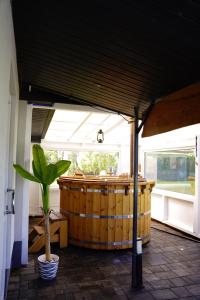 a large wooden barrel in a room with a potted plant at Siedlisko Staszkówka in Huszlew