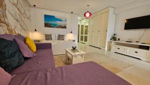 een woonkamer met een paarse bank en een tv bij Airport Residence 3 in Otopeni