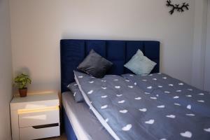 a blue bed with a blue headboard and pillows at Siedlisko Staszkówka in Huszlew +34 photos