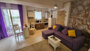 een woonkamer met een paarse bank en een keuken bij Airport Residence 3 in Otopeni