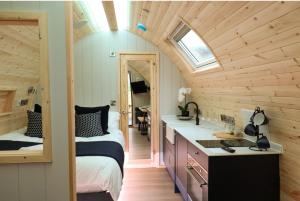 a small bedroom with a bed and a sink in a room at Primrose Glamping Pods in Ingleton 