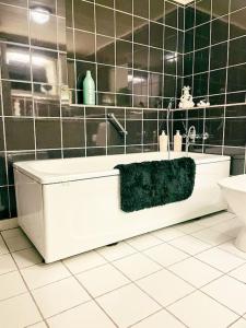 a bathroom with a white tub and a green towel at 3 BR home for 9 guests in a quiet neighborhood in Tórshavn +51 photos