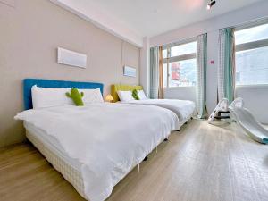 - une chambre avec 2 lits et une chaise dans l'établissement 旅人之宿Traveler Inn依預定人數開放房間數, à Hualien