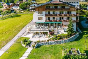 una vista aerea di un hotel con prato di Wiesenhof, Hotel direkt am See a Weissensee