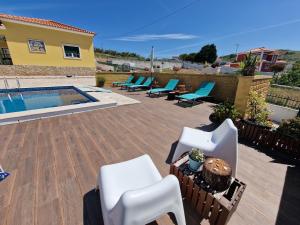 eine Terrasse mit Stühlen und einem Pool in der Unterkunft Porto Dinheiro Beach I in Lourinhã