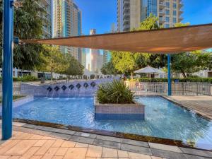 a swimming pool with a fountain in a city at Stunning 1-Bedroom Apartment with full Burj Khalifa View - 5-min walk to Dubai Mall in Dubai