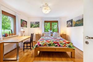 1 dormitorio con escritorio y 1 cama con colcha en Kiwi Retreat, en Bad Urach
