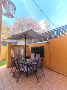 einen Tisch und Stühle mit Sonnenschirm auf einer Terrasse in der Unterkunft BEACH&GARDEN in Málaga