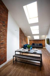 a living room with a table and a brick wall at The Garnet Suite in Manchester