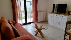 a living room with a couch and a flat screen tv at Apartments Villa Ksenija in Umag