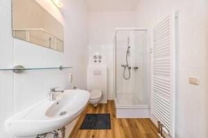 een witte badkamer met een wastafel en een douche bij Design Studio zentral Küche parknah in Leipzig
