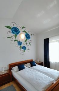 a bedroom with two beds with blue roses on the wall at Apartments Villa Ksenija in Umag