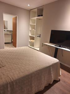a bedroom with a bed and a flat screen tv at Confortabile Apart in San Fernando del Valle de Catamarca