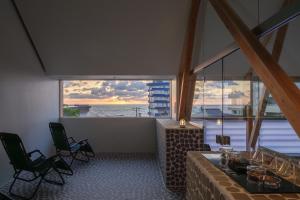 Zimmer mit einem Tisch und Stühlen sowie einem großen Fenster in der Unterkunft Kameya Hotel in Tsuruoka