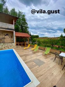 a patio with a pool and chairs and a table at Vila GUŠT in Zlatibor