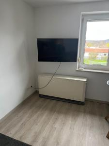 バート・シュタッフェルシュタインにあるFerienwohnung Bettinaの白い部屋で、薄型テレビ、窓が備わります。