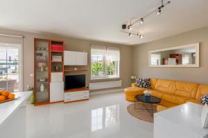 een woonkamer met een bank en een tv bij Apartment Sara Premium in Funtana