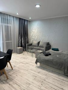 a living room with a bed and a couch at Стильная студия у Айрин с панорамным видом на гору ,,Арчук" in Vanadzor