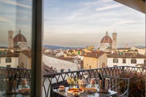 a view of a city from a balcony with food on a table at The Place Firenze in Florence