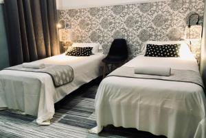 a room with two beds and a chair at Hostal Boutique Khronos in Barcelona