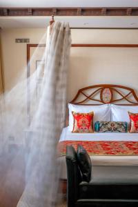 a bedroom with a bed and a window with curtains at The Grand Dragon Ladakh in Leh