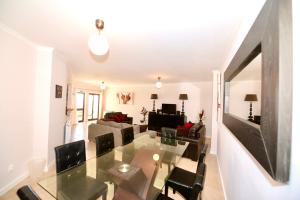 a living room with a glass table and chairs at Palm Tree in São Martinho do Porto