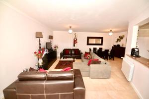 a living room with a brown leather couch and chairs at Palm Tree in São Martinho do Porto