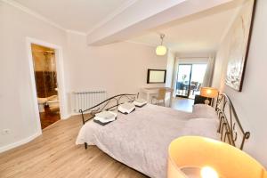 a bedroom with a large bed with a yellow chair at Palm Tree in São Martinho do Porto +39 photos