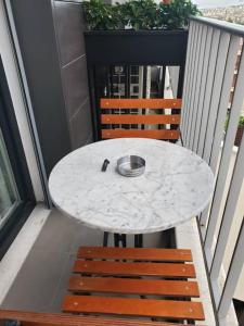Central Luxe Apartment في تيرانا: طاولة بيضاء و كرسيين على شرفة