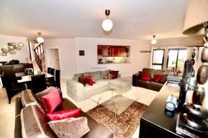 a living room with couches and red pillows at Palm Tree in São Martinho do Porto