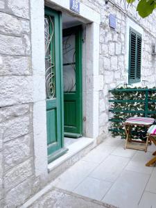 una puerta verde y una mesa frente a un edificio en Studio apartman Perla en Split