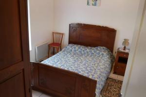 ein kleines Schlafzimmer mit einem Bett und einem Stuhl in der Unterkunft La Grande maison de pays in Saint-Hilaire-de-Riez