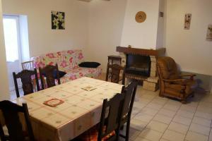 ein Wohnzimmer mit Tisch und Kamin in der Unterkunft La Grande maison de pays in Saint-Hilaire-de-Riez