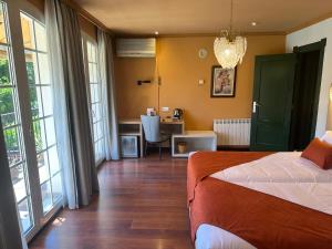 a bedroom with a bed and a desk with a table at Hotel Boutique Cortijo Landete - SOLO ADULTOS in Granada