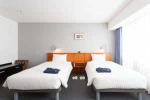 a hotel room with two beds and a piano at Sun Days Kagoshima in Kagoshima