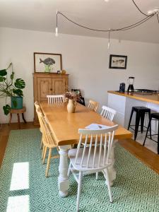a dining room with a wooden table and chairs at Joli appartement proche dunes d'Erdeven & Ria Etel in Erdeven