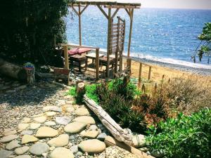 - un kiosque et un banc sur la plage dans l'établissement Shambala Beach House-where mountains meet the sea, à Pomos