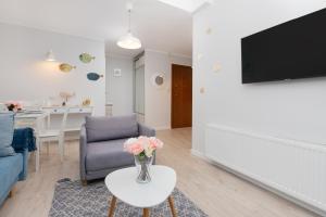 un soggiorno con un vaso di fiori su un tavolo di Dębki Wakacyjny Apartament blisko Plazy Liliowa by Noclegi Renters a Dębki