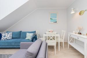 un soggiorno con un divano blu e un tavolo di Dębki Wakacyjny Apartament blisko Plazy Liliowa by Noclegi Renters a Dębki