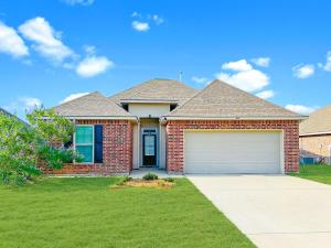 a brick house with a garage on a lawn at Plush Bedshigh-speed Wi-fi Workspace in Lake Charles