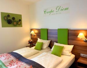 2 camas en una habitación de hotel con detalles verdes en Altdeutsche Weinstube - Superior, en Rüdesheim am Rhein