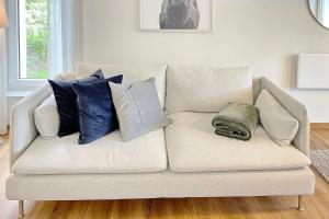 ein weißes Sofa mit Kissen darauf im Wohnzimmer in der Unterkunft Admiral in Lübbenau