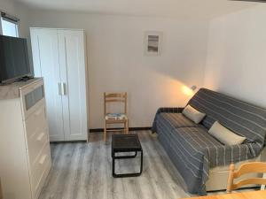 a living room with a couch and a tv at Natha de la Plage 2000 in Brétignolles-sur-Mer