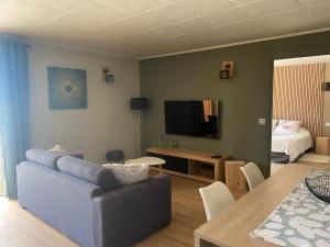 モントルーにあるGITE LAC DE SAINT CASSIENのリビングルーム(青いソファ、テレビ付)