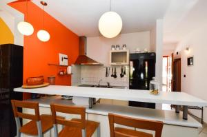 uma cozinha com um balcão branco e paredes cor-de-laranja em Volme em Banjole