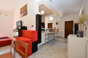uma cozinha e sala de estar com cadeiras vermelhas e um balcão em Volme em Banjole