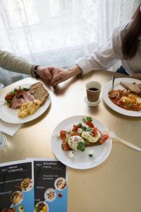 duas pessoas sentadas numa mesa com pratos de comida em Royal Grand Hotel em Kiev