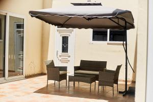 a table and chairs under an umbrella on a patio at Beautiful one bed apartment in Tema Community 6 in Tema